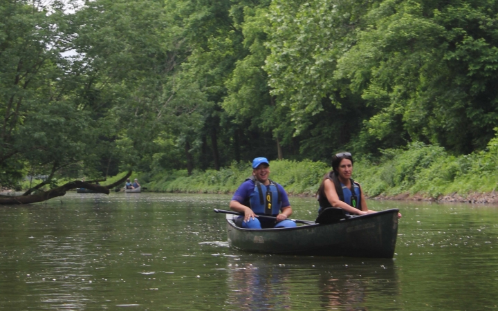 two people paddle a canoe on a wilderness expedition with outward bound